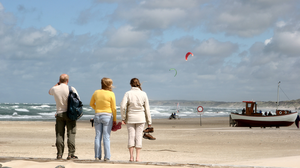 Tre personer på en strand.